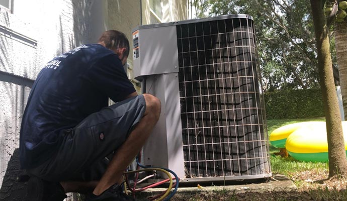 A technician servicing the air conditioning unit.