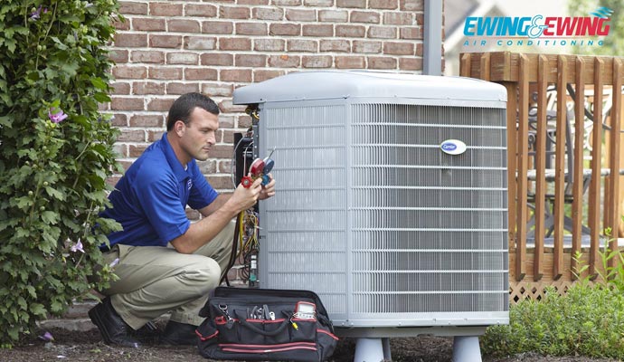 a man servicing carrier ac unit outside the house