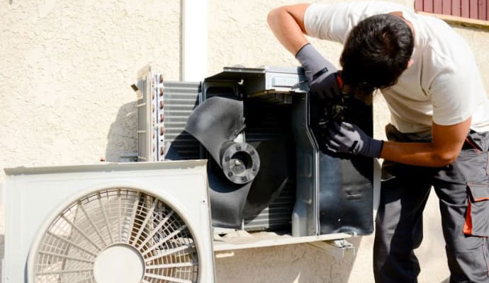 professional worker replacing outdoor AC unit